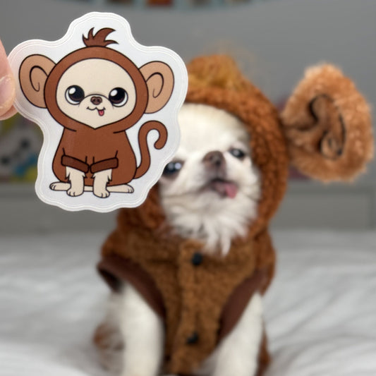 Dog in a monkey costume with a sticker of a monkey held up in front