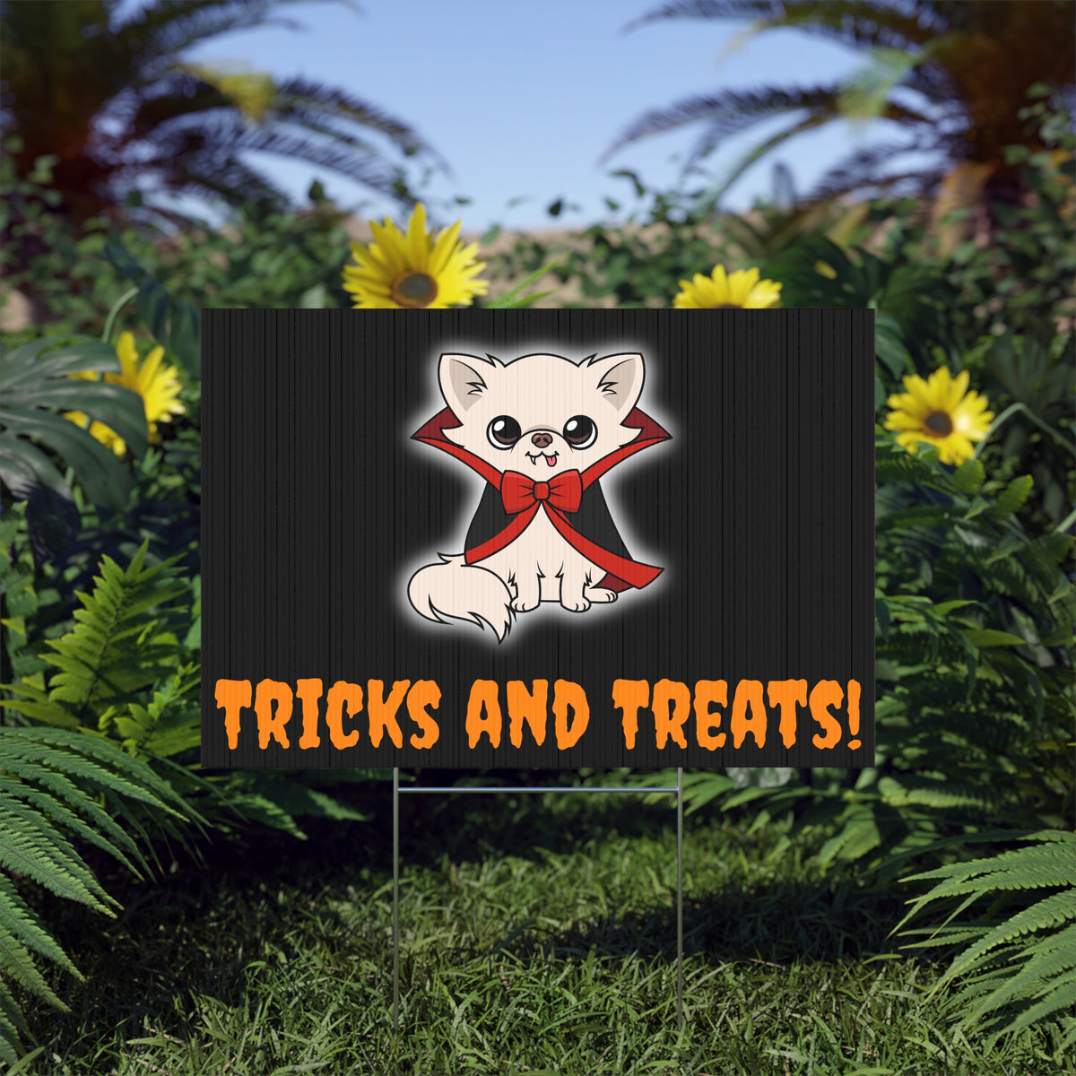 Halloween lawn sign showing a cream chihuahua as a cute vampire in a black cape with red lining and bow, above orange text that reads “TRICKS AND TREATS!” on a dark wood-style background, displayed on a metal stake in a garden.