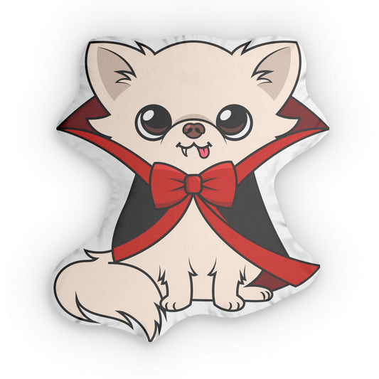 Custom-shaped pillow featuring Cedric, a cream chihuahua cartoon sitting upright in a black cape with red trim and a large red bow, tiny fangs and tongue showing, on a white background.