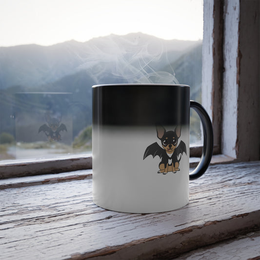 Color-changing mug on a rustic windowsill, with a black top fading to white and a cute black-and-tan chihuahua with bat wings printed near the bottom.