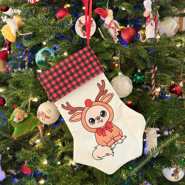 Christmas stocking with reindeer design hanging on a decorated Christmas tree.