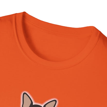 Woman sitting cross-legged on a living room rug wearing a charcoal unisex t-shirt with a centered illustration of a small black-and-tan chihuahua with bat wings, a white chest, and a tiny fang, shown from the front.