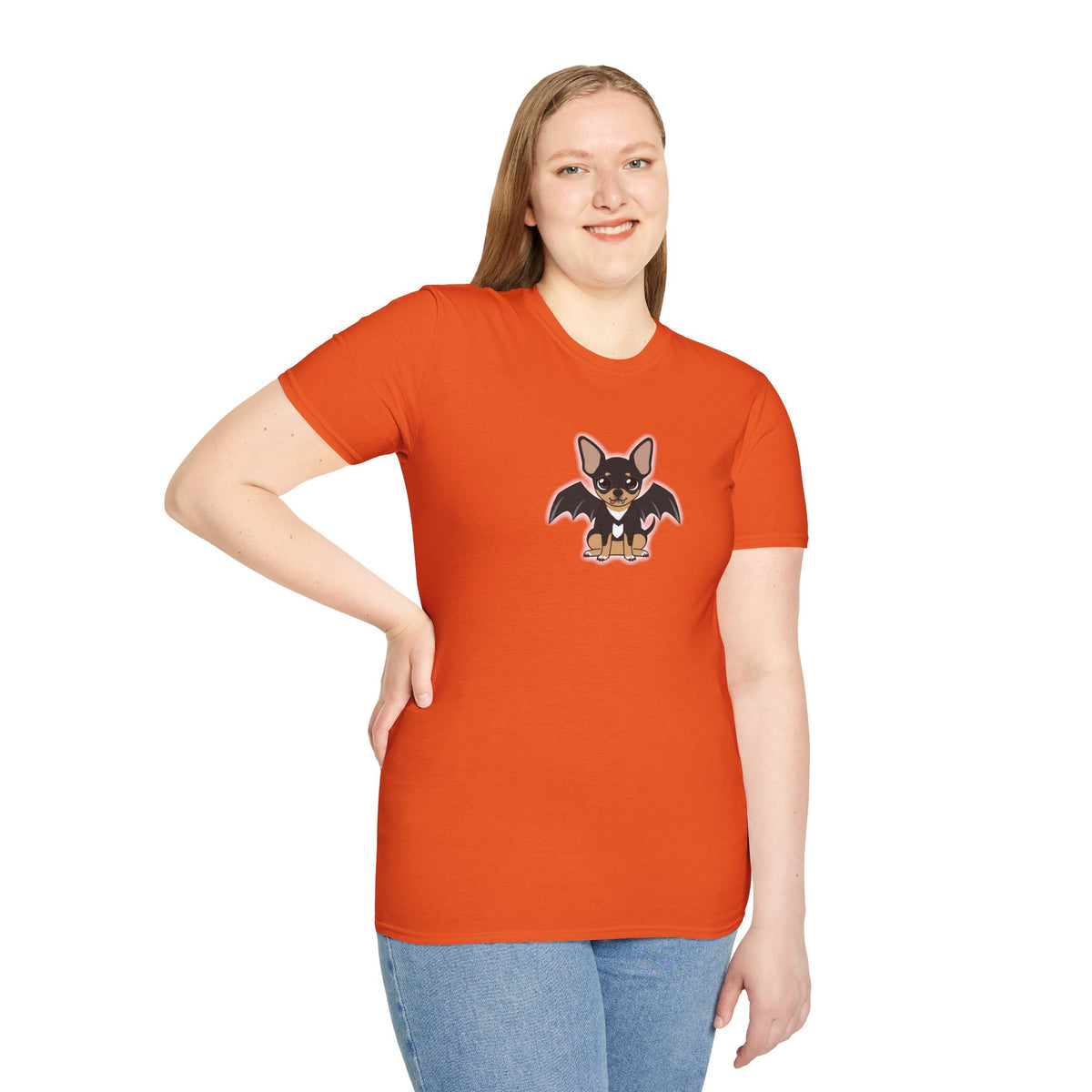 Person wearing a charcoal unisex t-shirt with a centered cartoon black-and-tan chihuahua, shown with bat wings, a tiny visible fang, and a soft white glow around its outline.