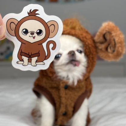 Dog in a monkey costume with a sticker of a monkey held up in front