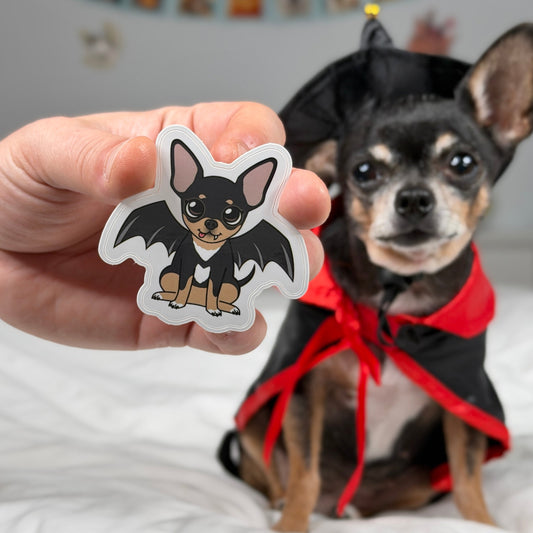 Die-cut sticker featuring Maya the Chihuahua in a vampire costume with bat wings.