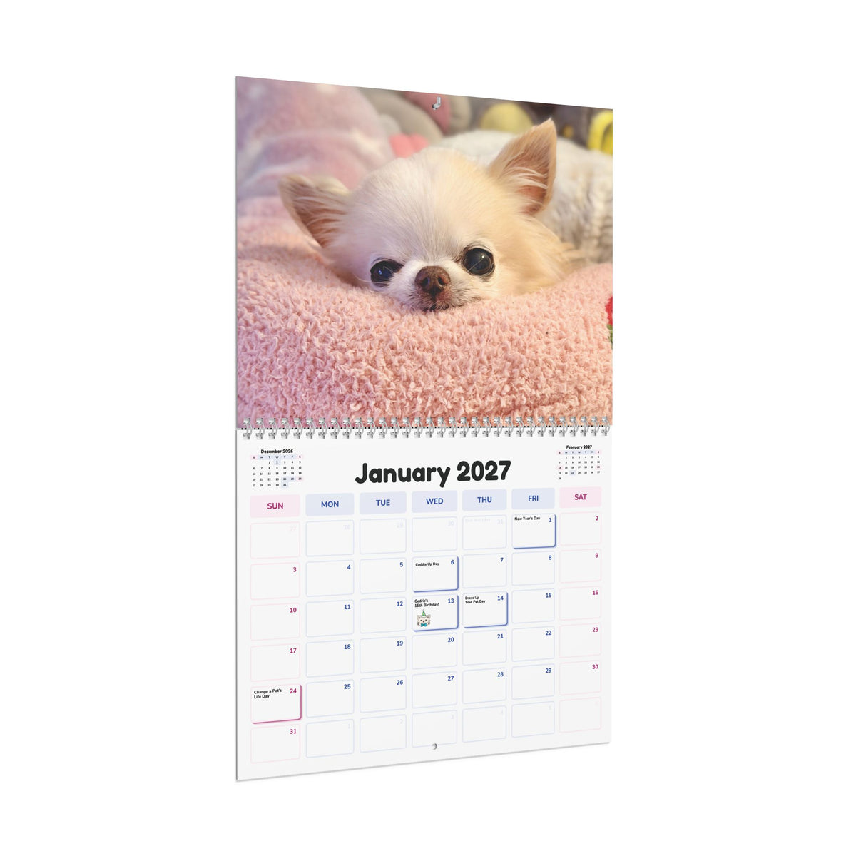 Angled view of the January 2027 calendar page with a cream Chihuahua peeking over a pink blanket.