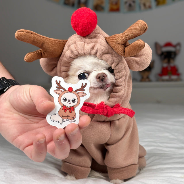 Dog in a reindeer costume sticker held in front of a matching dog in a reindeer costume.