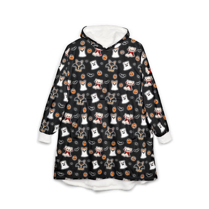 Front view of a black wearable hooded blanket covered in the Halloween Chis pattern, with a white lined hood and cuffs.