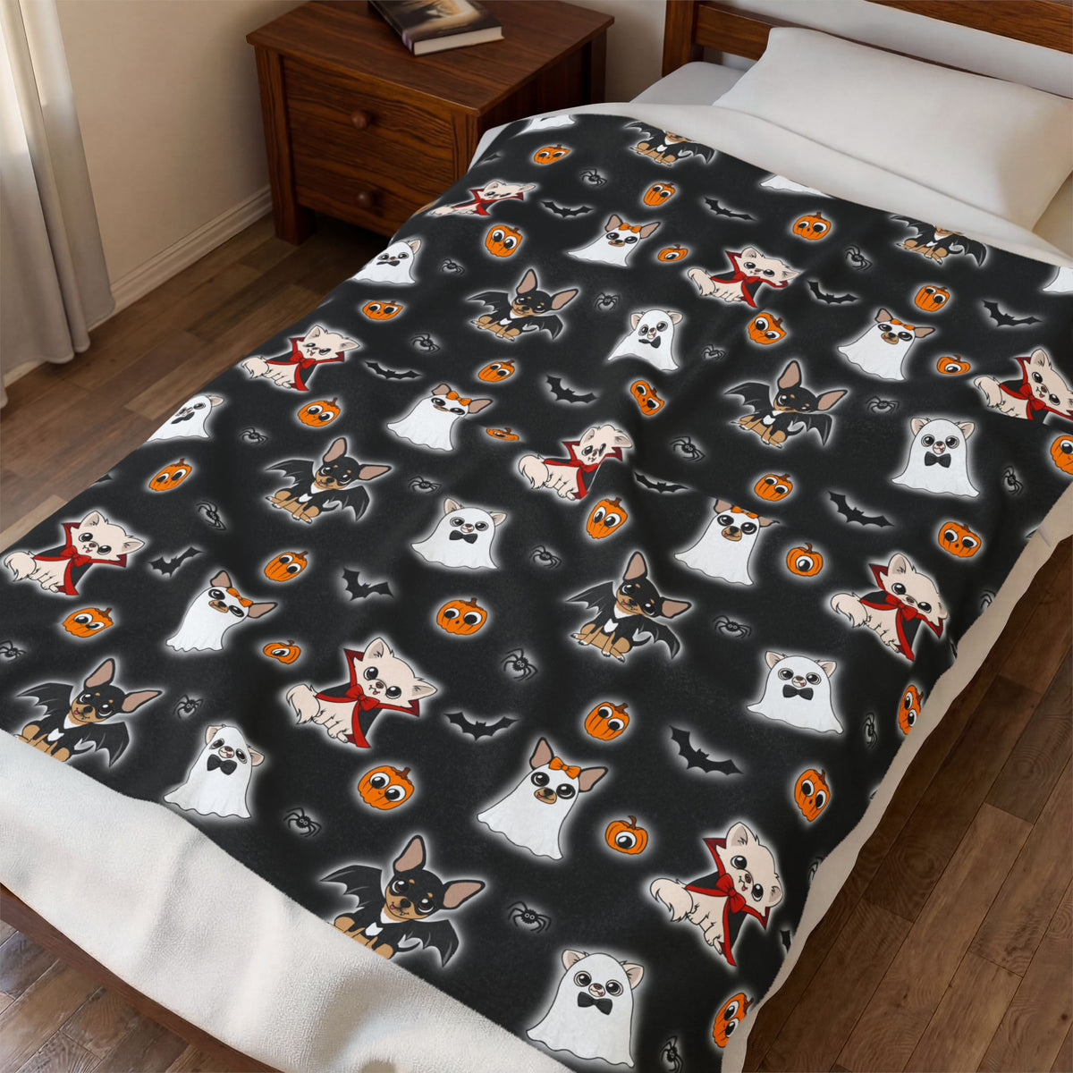 Halloween Chis blanket draped over a bed, showing the black patterned front and white reverse.