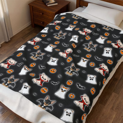 Halloween Chis blanket draped over a bed, showing the black patterned front and white reverse.
