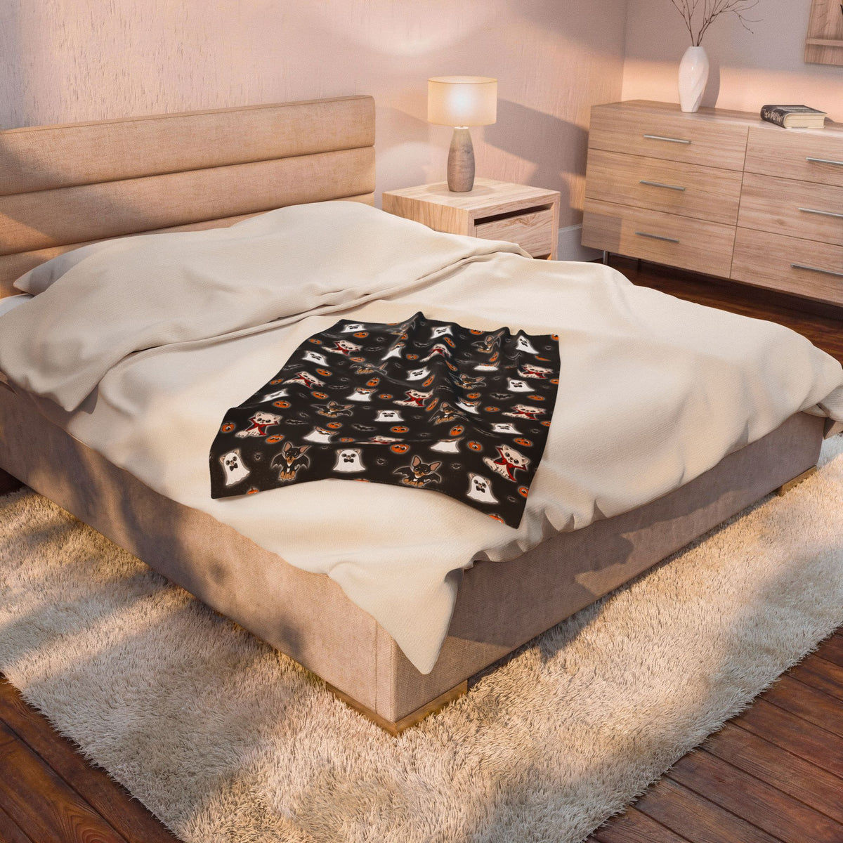 Folded Halloween Chis blanket placed on a bed, showing the black patterned front.