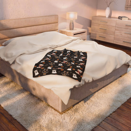 Folded Halloween Chis blanket placed on a bed, showing the black patterned front.