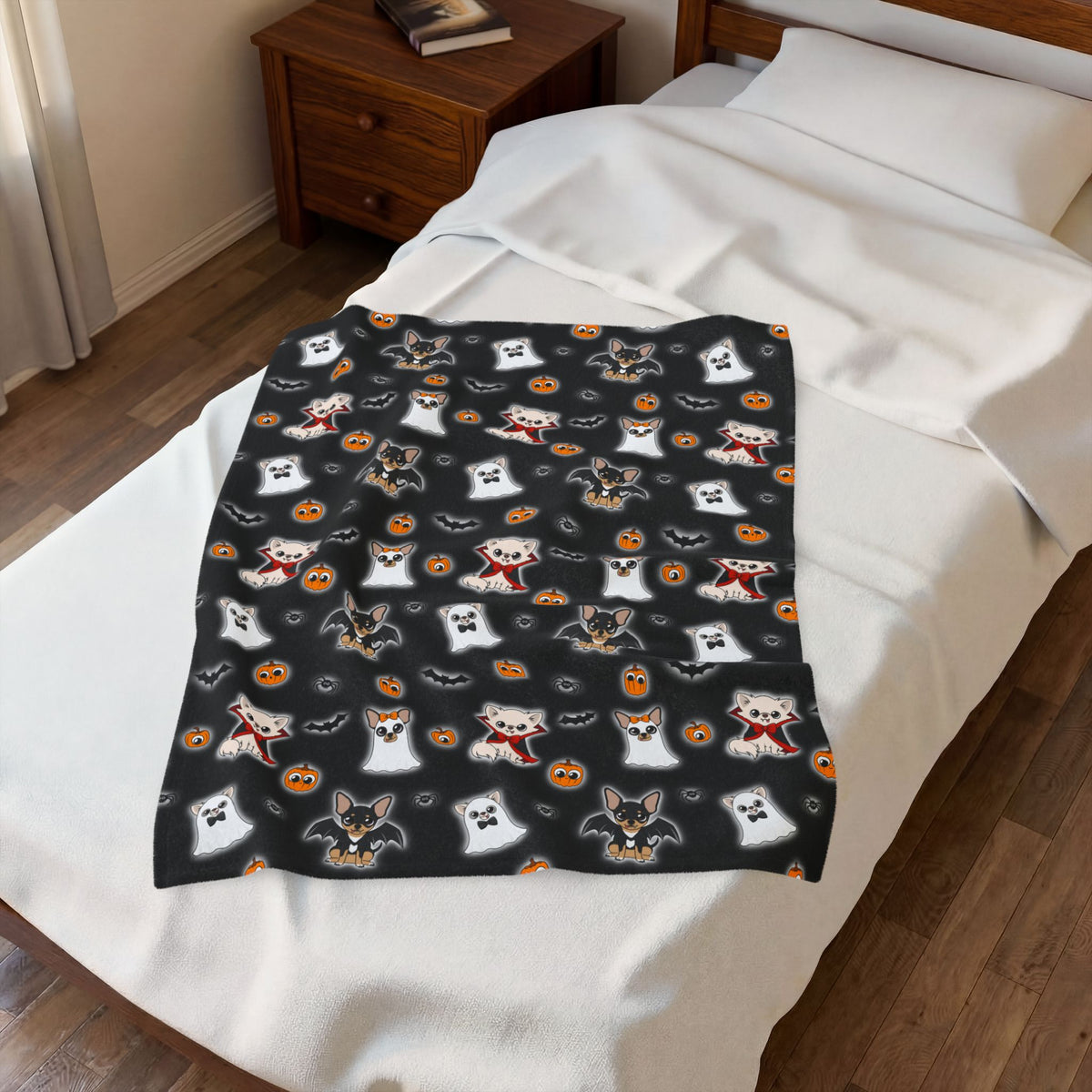 Halloween Chis blanket laid across the foot of a bed, showing its repeating black-ground print.
