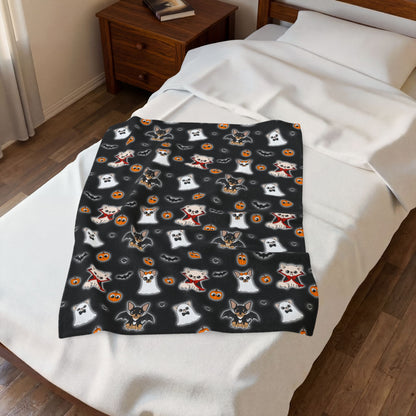 Halloween Chis blanket laid across the foot of a bed, showing its repeating black-ground print.