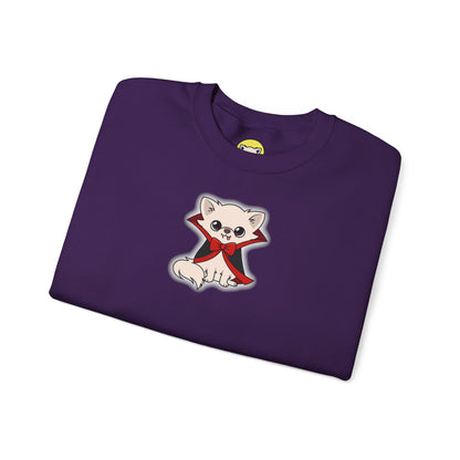 Folded purple crewneck sweatshirt featuring a cream chihuahua named Cedric sitting in a black cape with red lining and a red bow, outlined by a soft white glow on the chest.