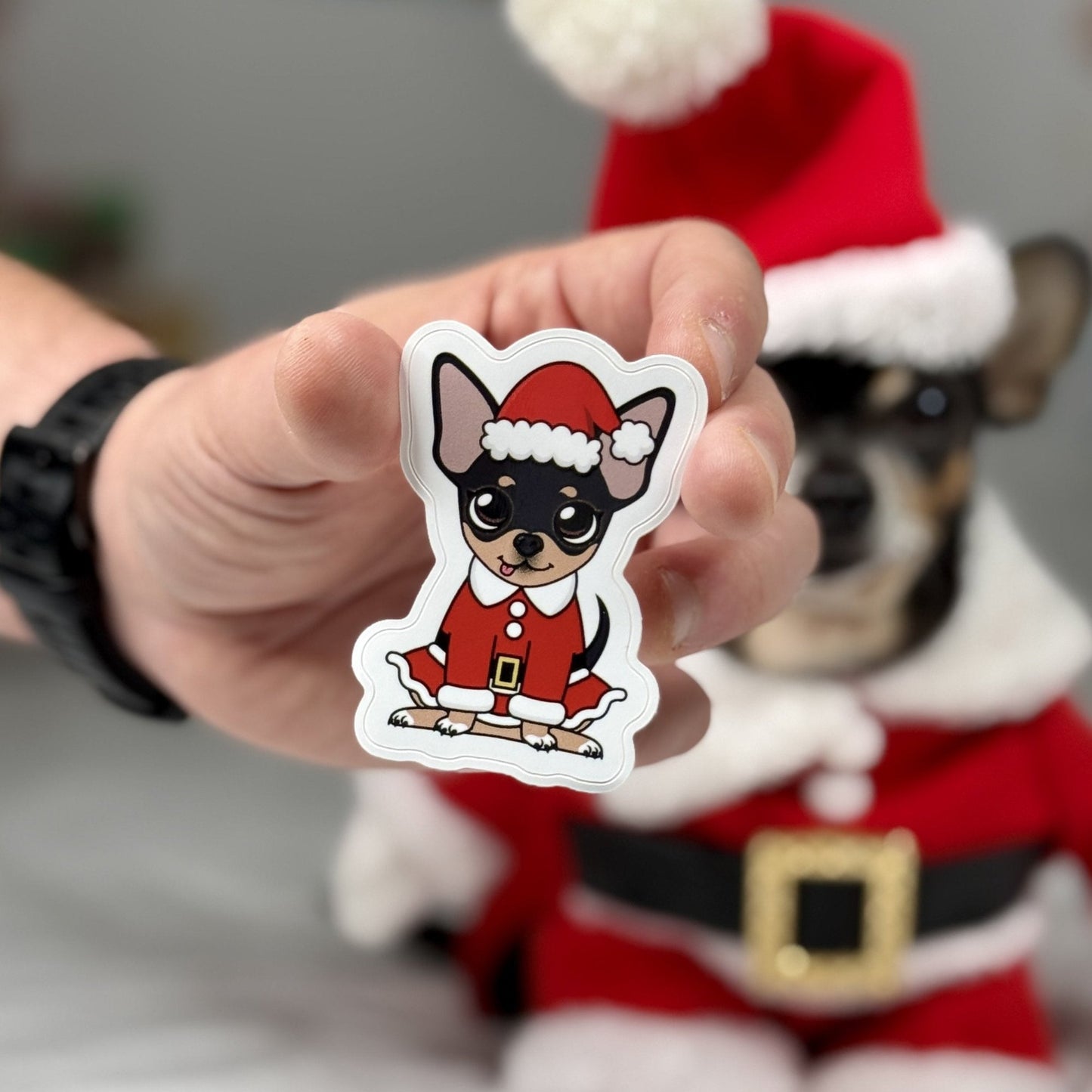 Santa Maya Sticker featuring a Chihuahua dressed in a festive red Santa Claus outfit with a pom-pom hat, perfect for holiday decorations.