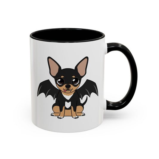 White coffee mug with black handle and interior, featuring a cute black and tan chihuahua with bat wings, big eyes, a tiny fang and a white heart-shaped chest marking on the front.